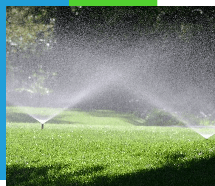 Sprinklers watering the grass on a sunny day.